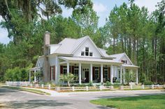 a large white house sitting on the side of a road in front of some trees