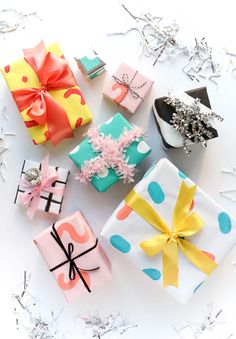 several wrapped gift boxes with bows on them and confetti sprinkles