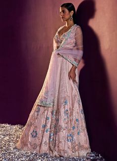 Introducing the exquisite Peach Multi Colour Sequins Embroidered Lehenga Set, crafted from the finest soft net for an opulent touch. This peach lehenga is adorned with intricate floral embroidery, delicately embellished with pearls, multicolor sequins, and crystals, creating a mesmerizing blend of shimmer and elegance. Teamed with a matching blouse featuring equally detailed embroidery that complements the lehenga perfectly, this ensemble is a true masterpiece. The look is elegantly finished with a sheer dupatta, showcasing a matching embroidered border, adding an extra layer of grace and sophistication. Ideal for Engagement or Roka ceremonies, this outfit promises to leave a lasting impression with its timeless charm and impeccable style. Composition : Lehenga, Blouse and Dupatta - Net Ca Anarkali Lehenga With Floral Embroidery In Tissue Silk, Peach Sharara With Intricate Embroidery, Wedding Lehenga With Floral Embroidery In Tissue Silk, Pink Embroidered Net Lehenga, Peach Anarkali Lehenga With Intricate Embroidery, Pink Semi-stitched Net Lehenga, Semi-stitched Peach Sharara With Intricate Embroidery, Peach Wedding Sets With Sheer Dupatta, Pink Net Lehenga With Resham Embroidery