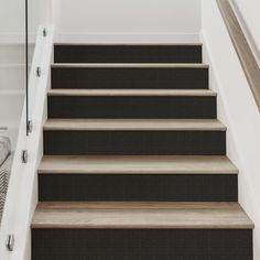 a set of stairs leading up to a bed in a room with white walls and carpet