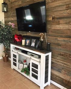 a flat screen tv mounted on top of a wooden wall