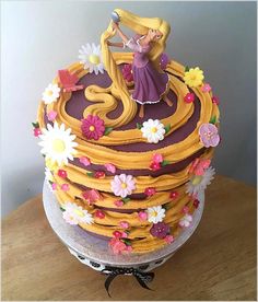 there is a cake that looks like it has been decorated with flowers and a princess figure on top