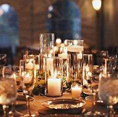 the table is set with candles, plates and silverware for dinner guests to enjoy