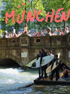 some people are standing on the edge of a bridge with surfboards in their hands