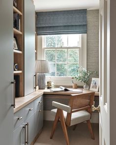 a home office with built in bookshelves, desk and chair by the window