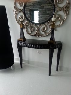 a mirror sitting on top of a table next to a black chair