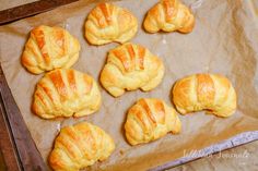 freshly baked croissants sitting on top of a baking sheet, ready to go into the oven