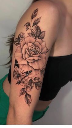 a woman's arm with a rose and butterfly tattoo on the left side of her arm