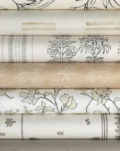 a stack of different types of fabric with flowers and leaves on them, all in various colors