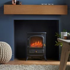 a living room with a fire place in the center and a chair next to it