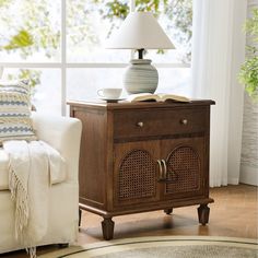 a living room with a white couch and a wooden cabinet in front of a window