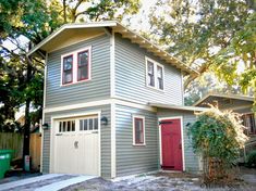 a gray house with red door and windows