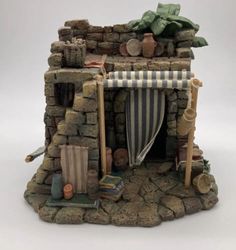 a miniature house made out of bricks and stone blocks with an awning over the door