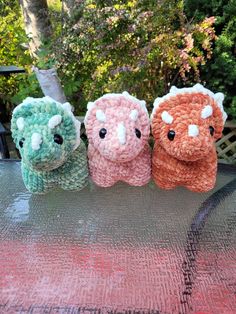 three small crocheted elephants sitting on top of a table next to each other