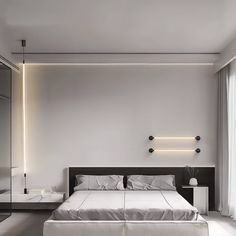 a modern bedroom with white walls and flooring is lit by the lights above the bed