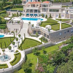 an aerial view of a mansion with a swimming pool and landscaping around the house is shown