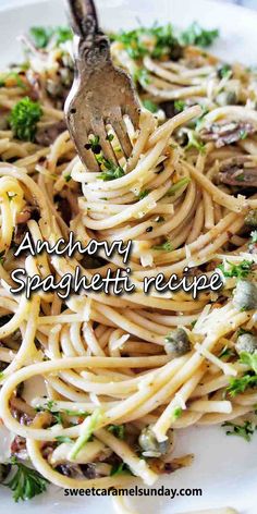 a white plate topped with pasta covered in mushrooms and parsley next to a fork