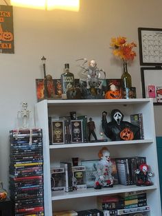 a white book shelf filled with lots of halloween books and decorations on top of it