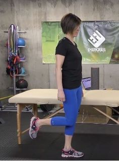 a woman in blue leggings standing next to a table