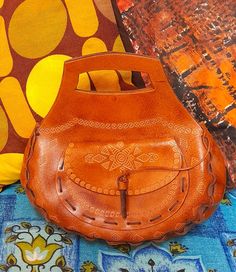 "70's handmade tooled leather bag🧡 Perfect for any lover of 70's boho style!🧡 Handmade, tooled leather with a lovely embossed pattern. Grab handle... lovely curved chunky design...handstitched with leather thonging...sweet pocket on the front..the flap closes with a loop and a length on bamboo (which is attached to a cord so you don't lose it)... Main bag closes with 2 hidden poppers🧡 Lovely vintage condition..only light wear🧡 🧡🧡MEASURES🧡🧡 12\" wide x 11\" tall to top of handles  x 4\" d Hand Tooled Festival Satchel Bag, Hand Tooled Leather Satchel For Festival, Vintage Hand Tooled Tote Satchel, Vintage Hand-tooled Tote Satchel, Vintage Style Hand Tooled Tote Satchel, Bohemian Brown Hand-tooled Shoulder Bag, Brown Leather Bohemian Satchel, Brown Bohemian Leather Satchel, Bohemian Brown Leather Satchel