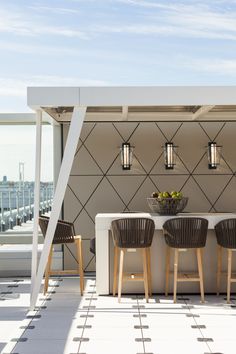 an outdoor dining area with three chairs and a table