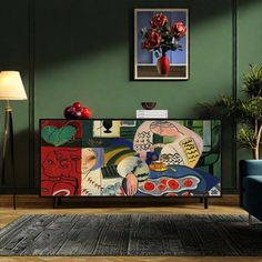 a living room with green walls and a painting on the sideboard in front of a blue couch