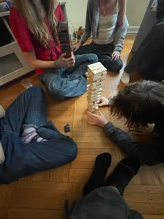 three people sitting on the floor playing with blocks