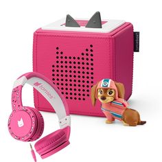 a little dog with headphones next to a pink speaker and earbud set