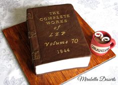 a book and mug sitting on top of a wooden table