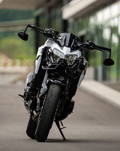 the motorcycle is parked on the side of the road in front of an office building