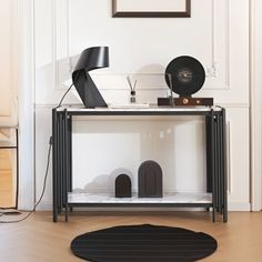 a black and white table with speakers on it in front of a framed photograph above