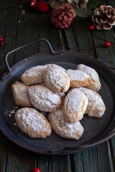 powdered sugar cookies on a black plate