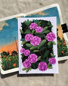 two cards with flowers on them sitting next to each other in front of a painting