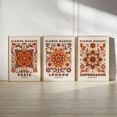 three flower market posters on the wall in an empty room with wood flooring and white walls