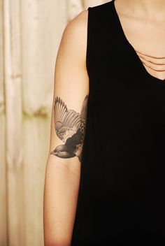 a woman with a bird tattoo on her arm