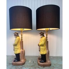 two lamps that are next to each other with a man holding a guitar on it