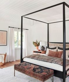 an instagram photo of a bedroom with a canopy bed and rug on the floor