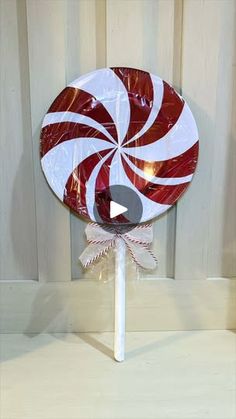 a lollipop on a stick with white and red stripes