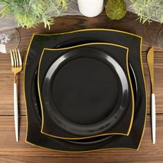 black and gold place setting with silverware on wooden table top, view from above