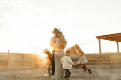 a group of people standing around each other in the dirt with one woman hugging another