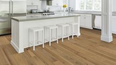 a kitchen with white cabinets and wooden floors