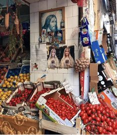 an outdoor market with fruits and vegetables for sale in boxes on the side of the street