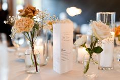 there are flowers in vases and candles on the table at this wedding reception,