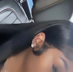 a woman with long black hair has ear piercings on her ears