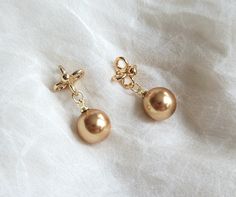 Gorgeous earrings feature 10 mm gold Swarovski pearls and gold plated brass floral filigree stud. Total length: 25 mm Floral filigree stud: 8*19 mm Purchase over $40 enjoys free shipping! Coupon code 'freeshipping1'. Free Gift Wrapping on request - All items that are gift wrapped come in with a kraft box with raffia string and blank writing card.  Please leave a note if you need it upon ordering. Elegant Gold Clip-on Earrings As Gift, Elegant Gold Clip-on Earrings For Gift, Wedding Earrings Gold, Gold Pearl Drop Earrings, Drop Earrings Wedding, Pearl Drop Earrings Gold, Floral Filigree, Code Promo, Earrings Wedding