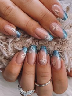 This elegant winter nail art features a glittery blue French tip with delicate white snowflakes. The clear base highlights the festive snowflakes, while the shimmering blue adds a frosty touch, perfect for a holiday or winter-themed look. Snowflake Nail Design, Blue Nail Designs, White Nail Designs, Blue Nail