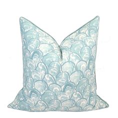 a blue and white pillow with wavy waves on the front, sitting on a white surface