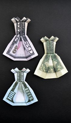 three origami dresses made out of one hundred dollar bills on a black background