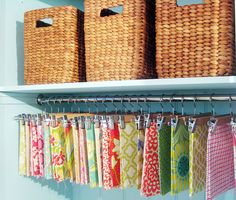 some baskets and towels hanging on a shelf