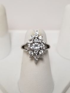 "Thanks for shopping our vintage estate store. We tend to sell well below wholesale and truly hope you enjoy all of our items. Many of the items are one of a kind, so please enjoy scrolling through the pictures and hopefully something will catch your eye. Brown spots are from camera or reflections. Beautiful estate 10k white gold 1ct CZ diamond waterfall cocktail ring. Sweet ring, one that you will love. Gems are testing natural, so they might be bright white topaz or iolite. Ring size: 4 Setting: 3/4\" by 3/8\" Band width: 2mm Weight: 3.52 grams There are 24 cz diamonds that are approx. 1ct tw. Marked 10k." Classic Cluster Ring With Vs Clarity, Cluster Ring With Vs Clarity Cubic Zirconia, Anniversary Cluster Ring With Cubic Zirconia, Classic Marquise Cut Cubic Zirconia Cluster Ring, Classic Cubic Zirconia Marquise Cut Cluster Ring, Vintage Cubic Zirconia Cluster Ring With Halo Setting, Vintage Diamond Cluster Ring With Vs Clarity, Classic Hallmarked Cluster Ring With Cubic Zirconia, Vintage Cubic Zirconia Ring With Halo Setting